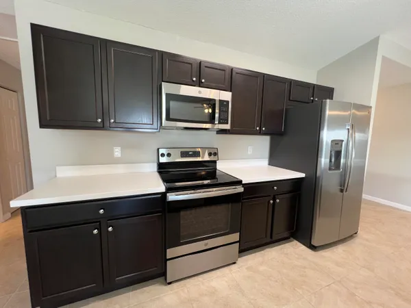 a kitchen with stainless steel appliances granite countertop a refrigerator and a sink