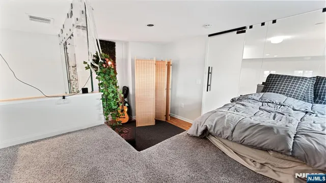 a bedroom with a bed and a potted plant