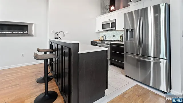 a kitchen with stainless steel appliances granite countertop a refrigerator and a stove top oven