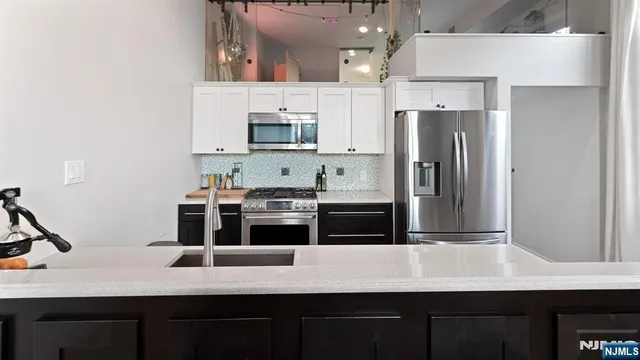 a kitchen with stainless steel appliances a refrigerator and a stove