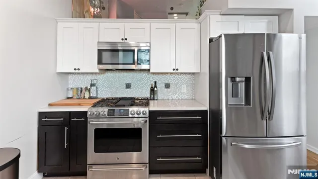 a kitchen with stainless steel appliances a stove a microwave and a refrigerator