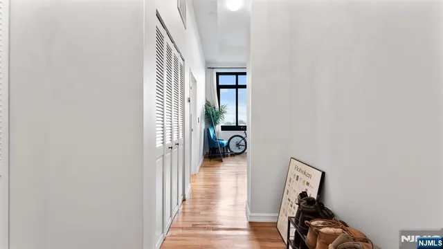 a view of a hallway with wooden floor and a living room