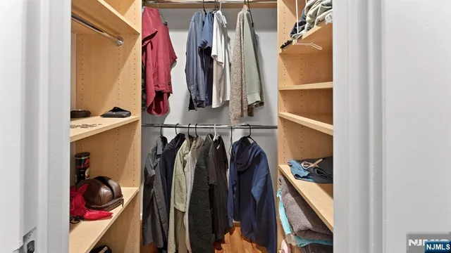 a view of walk in closet with clothes and shoes