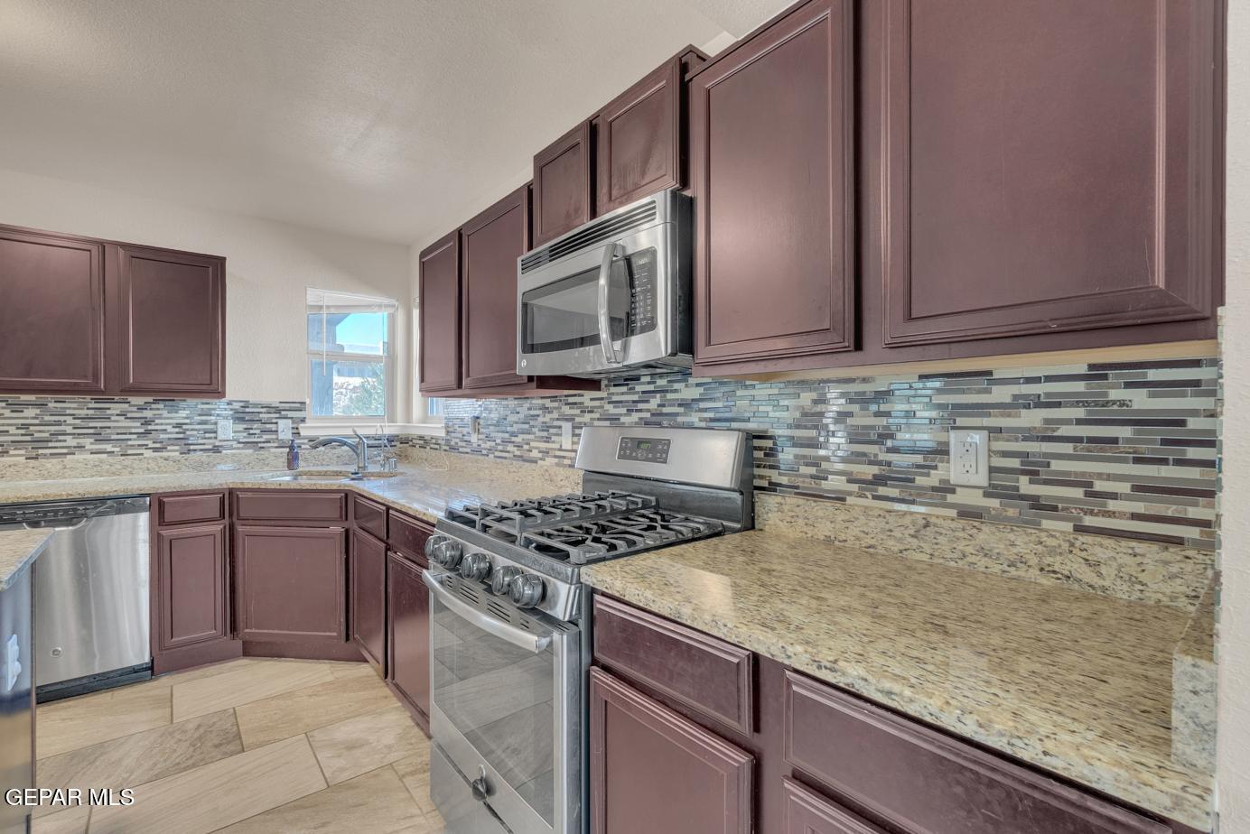 11349 West Ranch Court El Paso, TX 79934 - Photo 24 of 61 a kitchen with stainless steel appliances granite countertop a sink stove and microwave