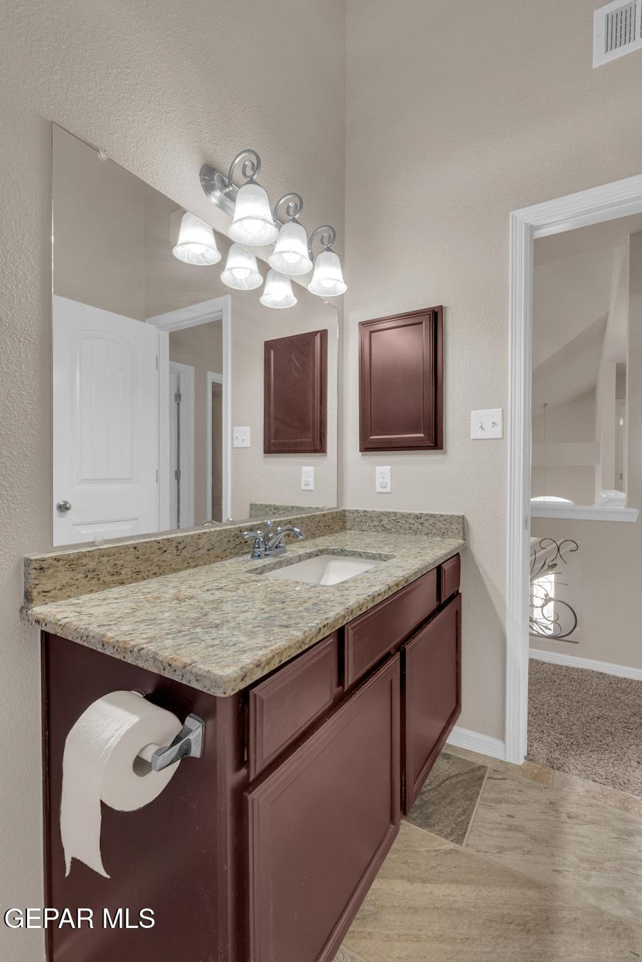 11349 West Ranch Court El Paso, TX 79934 - Photo 42 of 61 a bathroom with a granite countertop sink a toilet and mirror