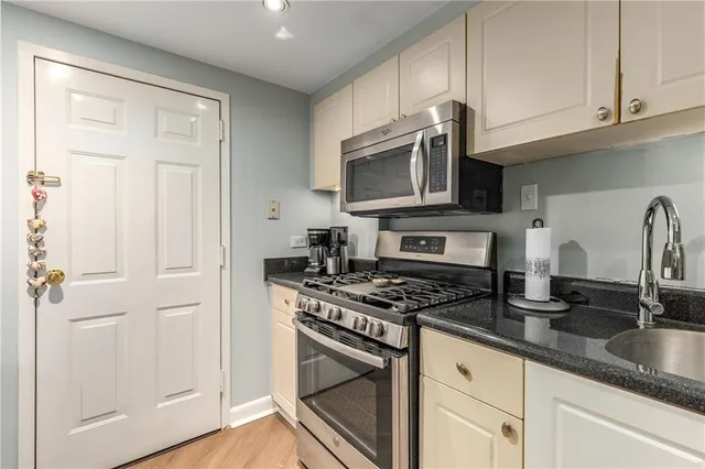 a kitchen with granite countertop cabinets stainless steel appliances and a sink
