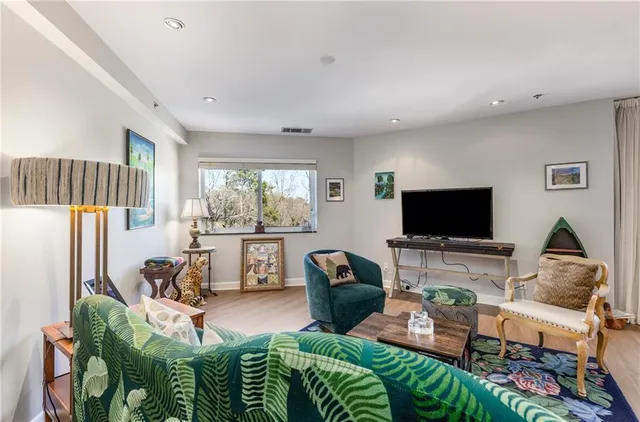 a living room with furniture a flat screen tv and a floor to ceiling window