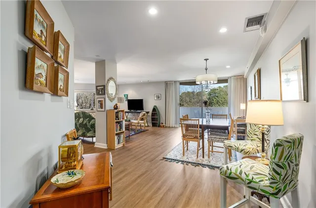 a living room with furniture a large window and wooden floor