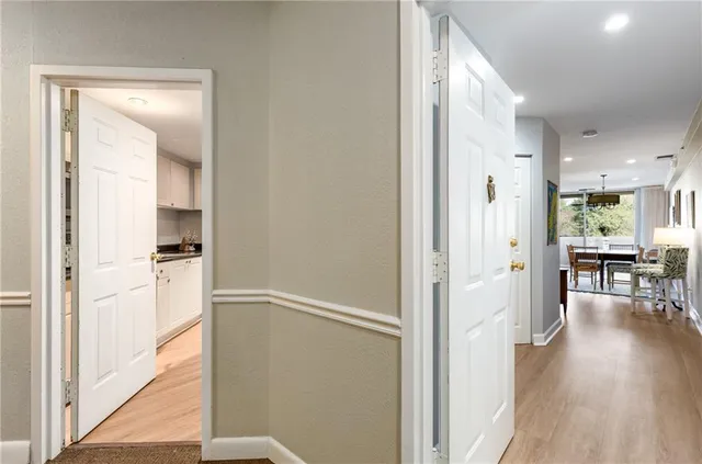 a view of a hallway with dining room and wooden floor