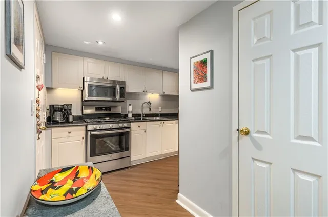 a kitchen with stainless steel appliances granite countertop a stove a sink and a refrigerator