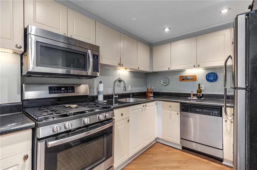1501 Clairmont Road, Unit 535 Decatur, GA 30033 - Photo 10 of 34 a kitchen with granite countertop cabinets stainless steel appliances and wooden floor