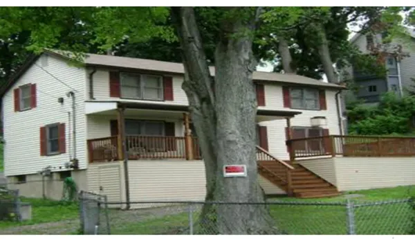 a view of a white house with large windows and a yard