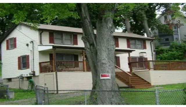 a view of a white house with large windows and a yard