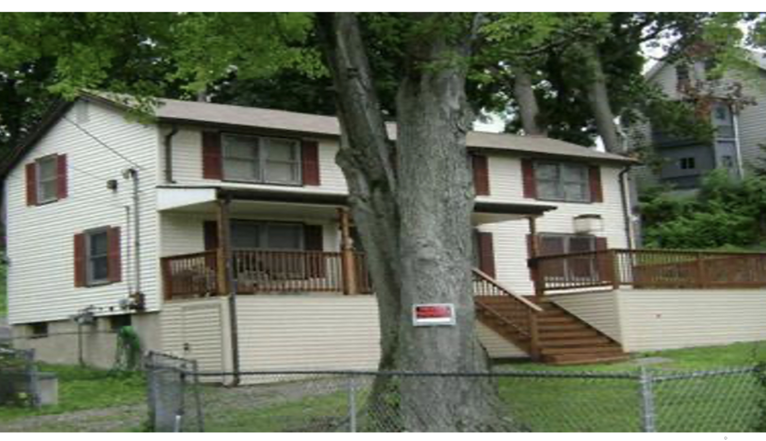 a view of a white house with large windows and a yard
