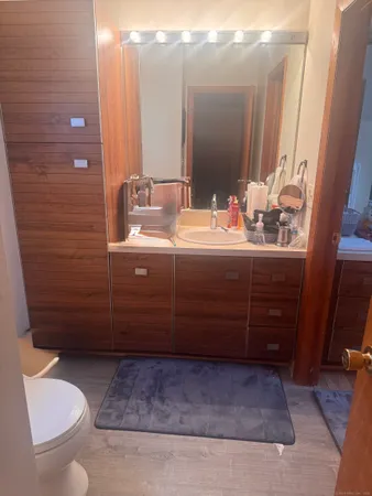 a bathroom with a sink vanity mirror and toilet