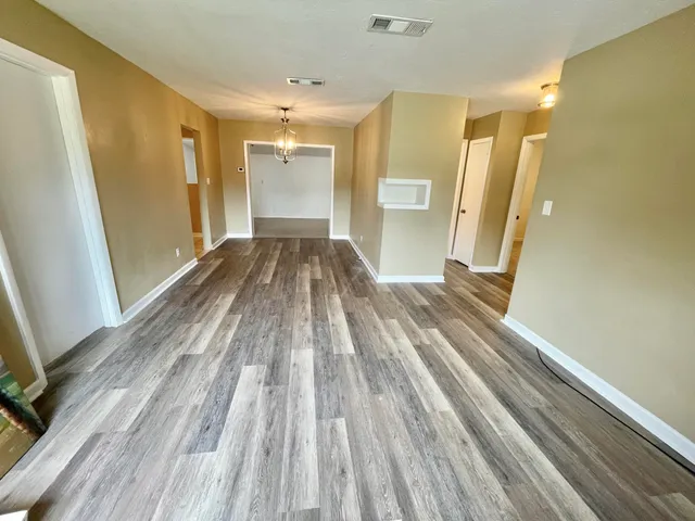 a view of a bedroom with wooden floor and a sink
