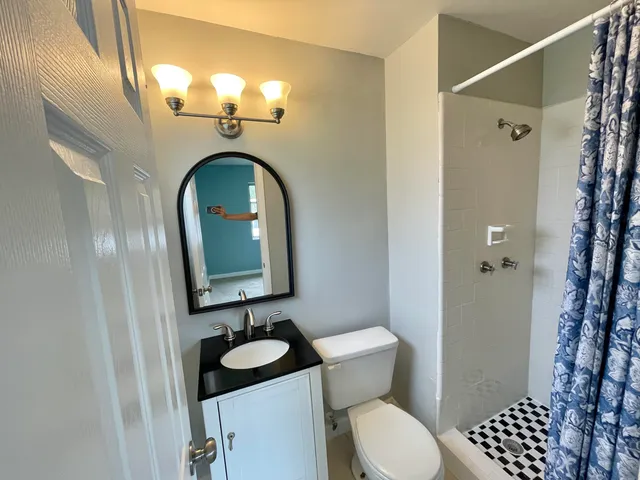 a bathroom with a toilet a sink and shower