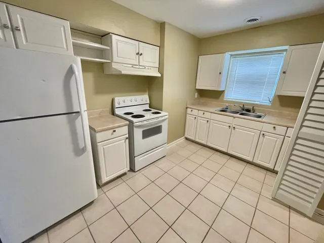 a kitchen with stainless steel appliances a stove a refrigerator and a cabinets
