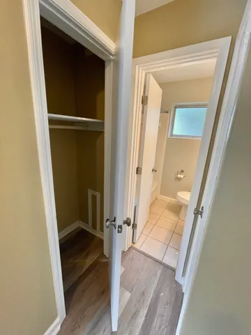 an empty room with windows and chandelier fan