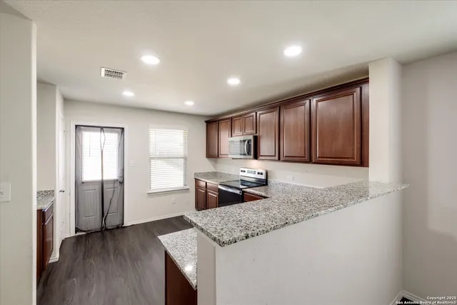 a kitchen with stainless steel appliances granite countertop refrigerator sink and cabinets