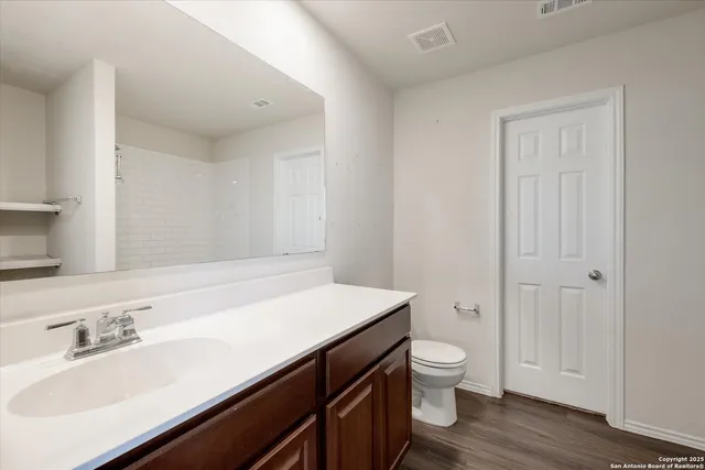 a bathroom with a sink a toilet and a large mirror