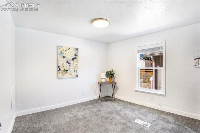 8440 Piute Road Colorado Springs, CO 80926 - Photo 18 of 34 Huge bedroom with abundant space, soft carpeting, and plenty of natural light—perfect for comfort and versatility or office use