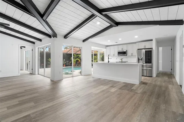 a view of an empty room with wooden floor and staircase