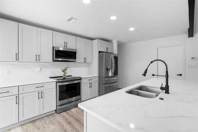 a spacious bedroom with a bed a couch and a potted plant