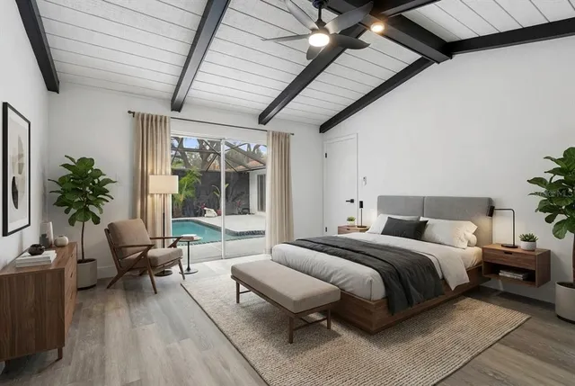 a view of an empty room with wooden floor and fan