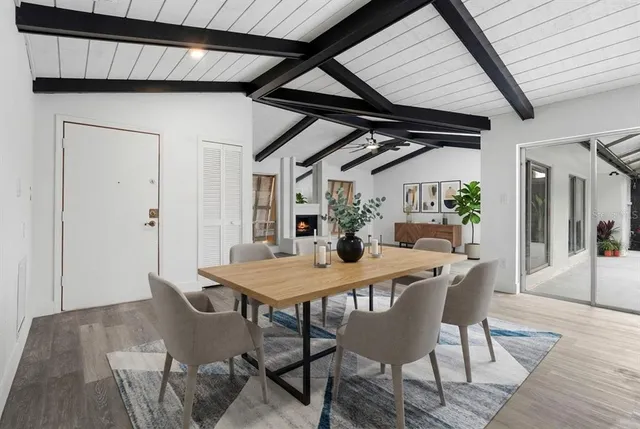 a view of an empty room with wooden floor fireplace and a window
