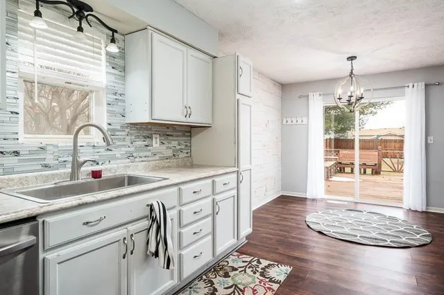 a kitchen with granite countertop a sink stove and cabinets