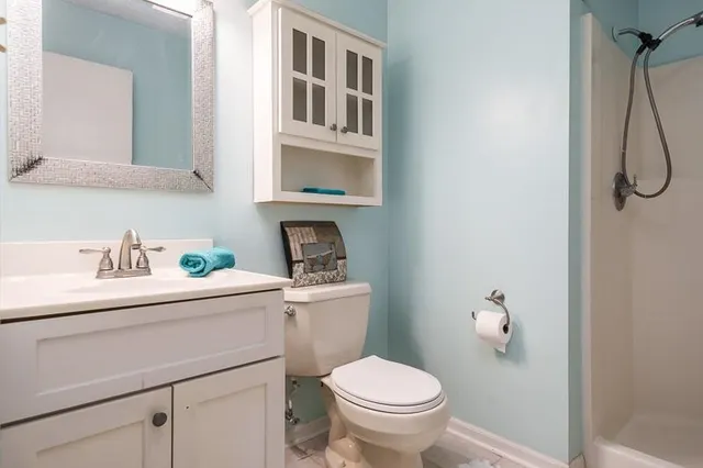 a bathroom with a sink toilet and a mirror