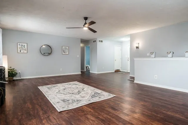 a view of a big room with wooden floor and a ceiling fan