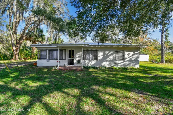 a front view of a house with garden and a patio