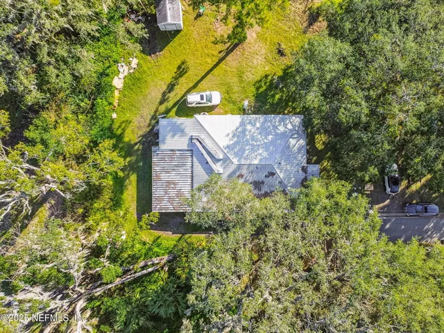 a view of a house with backyard and a tree