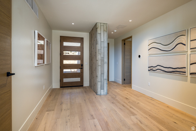 214 Lionsback Loop, Unit 37 Moab, UT 84532 - Photo 3 of 21 Entryway featuring light wood-finish flooring, a modern wood-paneled door with frosted glass inserts, a textured accent wall, recessed lighting, and crisp white trim