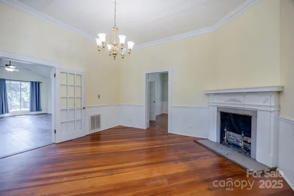 a view of empty room with wooden floor and fireplace