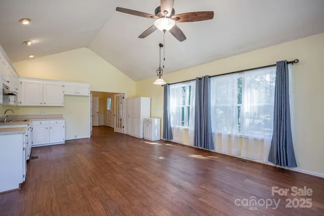 a view of a kitchen with wooden floor and a ceiling fan