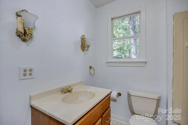a bathroom with a sink a toilet and a window