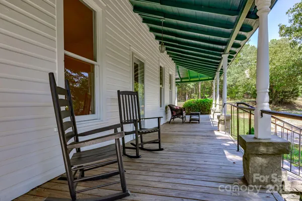 a view of a porch with furniture and wooden floor
