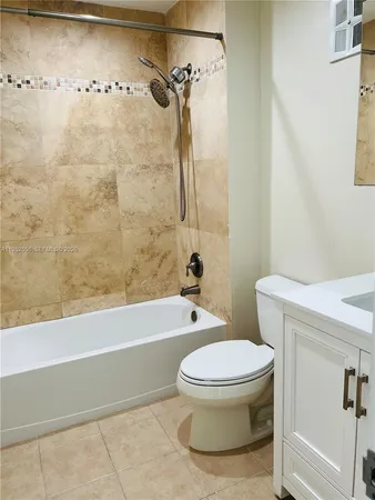 a white toilet sitting next to a bath tub and a shower