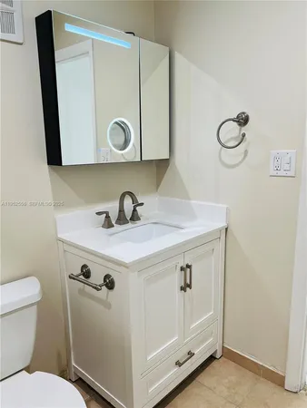a bathroom with a sink a toilet and a mirror