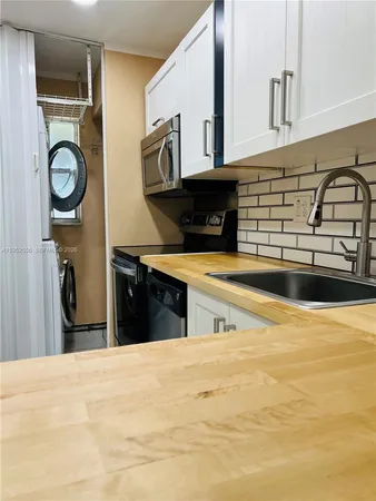 a kitchen with stainless steel appliances kitchen island a stove a sink and a refrigerator