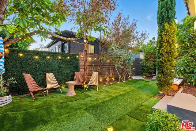 a backyard of a house with swimming pool and outdoor seating