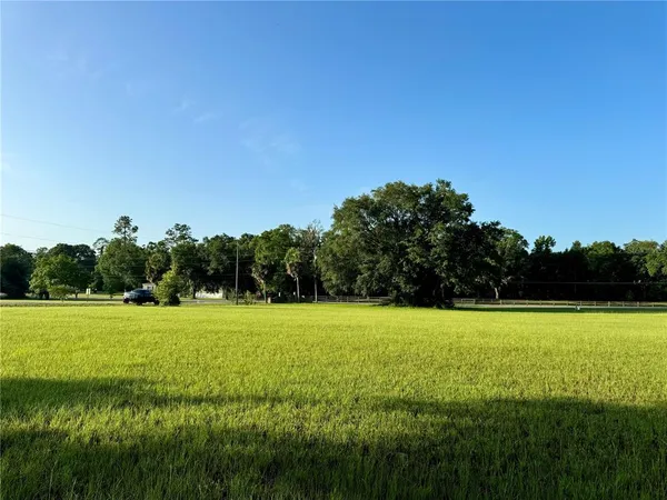 a view of a green field with a lake
