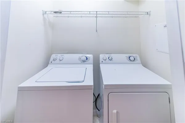 an empty room with windows and chandelier fan