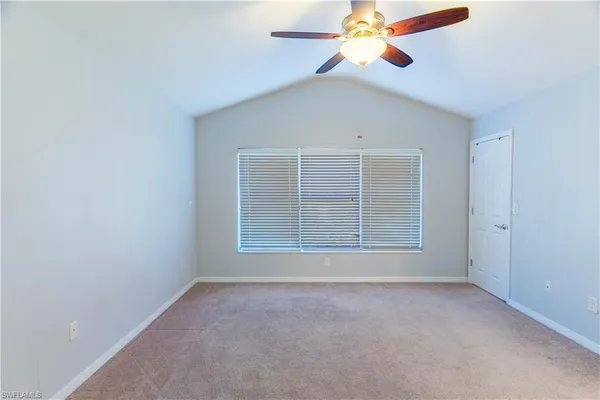 an empty room with chandelier fan