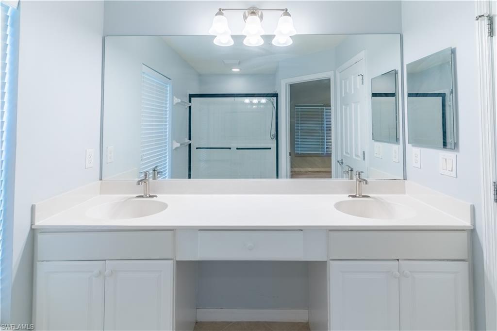 16146 Caldera Lane, Unit 31 Naples, FL 34110 - Photo 27 of 35 a bathroom with a sink and a mirror