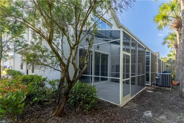 a backyard of a house with plants and large trees