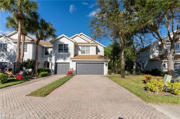 a front view of a house with a yard and potted plants